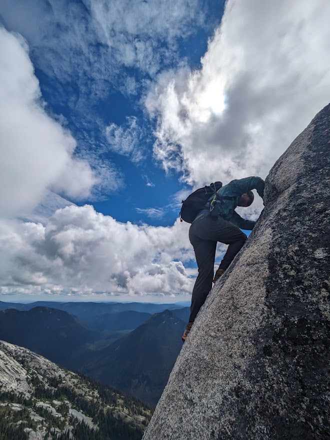 A climber downclimbing the steep granite step on the descent from Vicuna